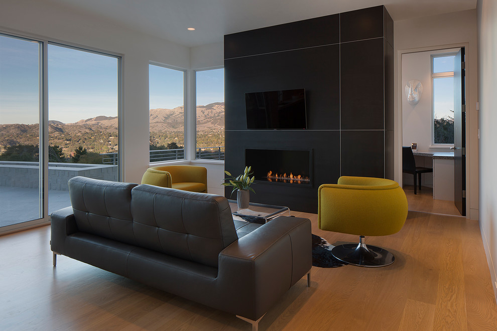 Großes, Repräsentatives, Abgetrenntes Modernes Wohnzimmer mit schwarzer Wandfarbe, braunem Holzboden, Kamin, Kaminumrandung aus Holz und TV-Wand in San Francisco