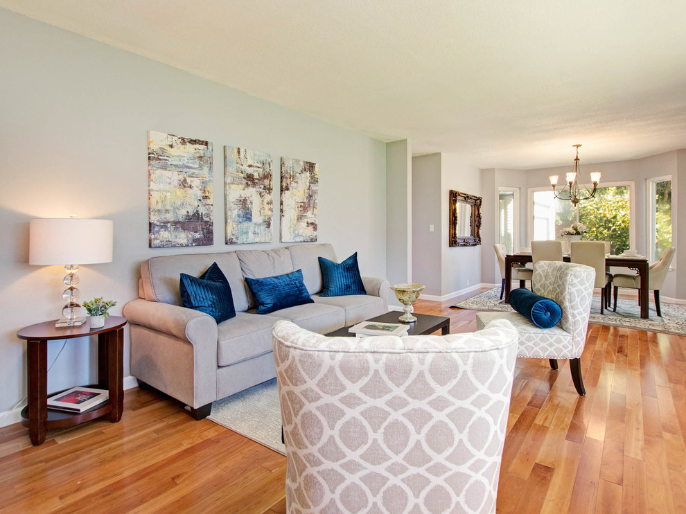 Идея дизайна: открытая гостиная комната среднего размера в стиле неоклассика (современная классика) с серыми стенами, паркетным полом среднего тона и коричневым полом без камина