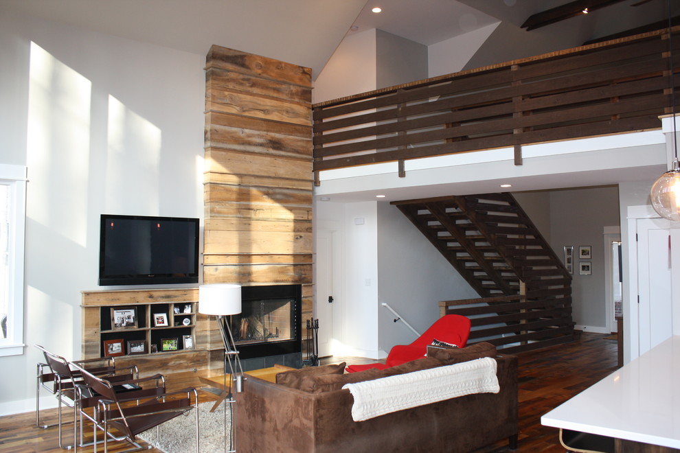 Idéer för mellanstora lantliga loftrum, med ett finrum, grå väggar, mellanmörkt trägolv, en standard öppen spis, en spiselkrans i trä och en väggmonterad TV