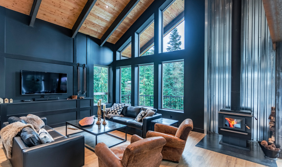 Foto di un ampio soggiorno moderno aperto con pareti nere, pavimento in vinile, stufa a legna, TV autoportante e pavimento marrone