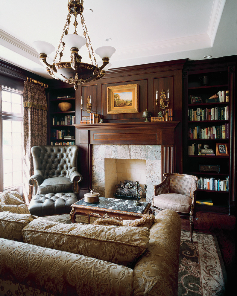 Пример оригинального дизайна: огромная изолированная гостиная комната в викторианском стиле с с книжными шкафами и полками, стандартным камином, коричневыми стенами, темным паркетным полом и фасадом камина из камня без телевизора