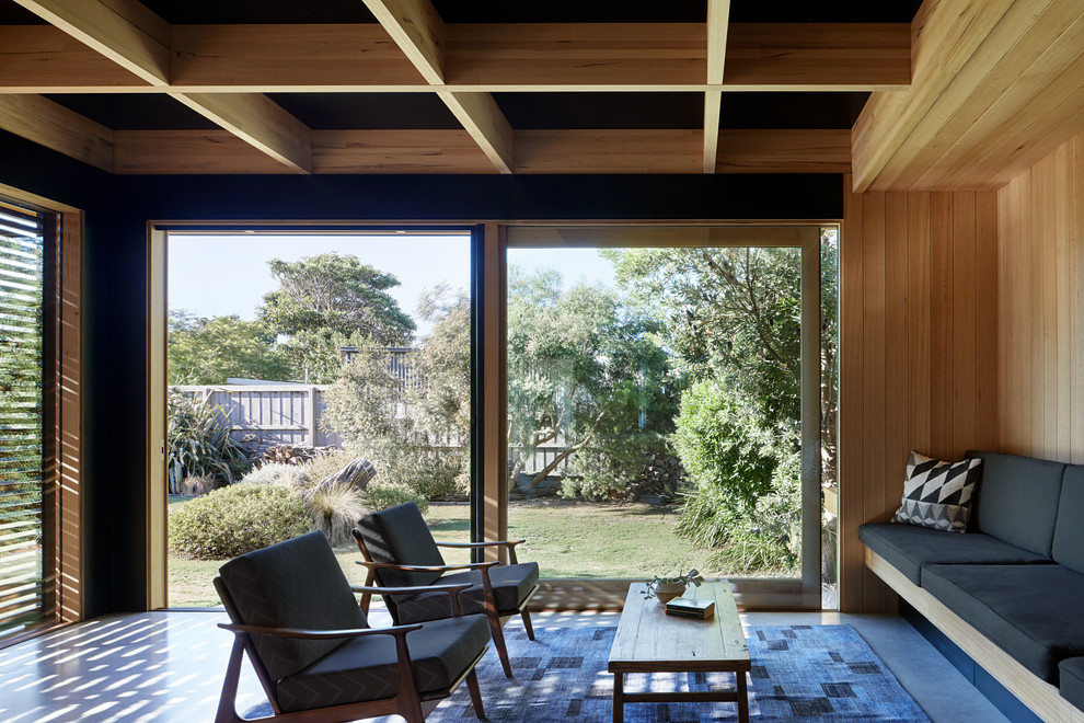 Идея дизайна: маленькая открытая гостиная комната в стиле ретро с коричневыми стенами и бетонным полом для на участке и в саду