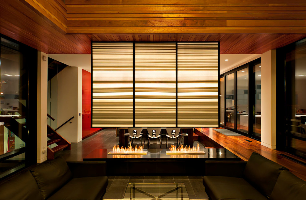Cette image montre un salon design ouvert avec une cheminée double-face.