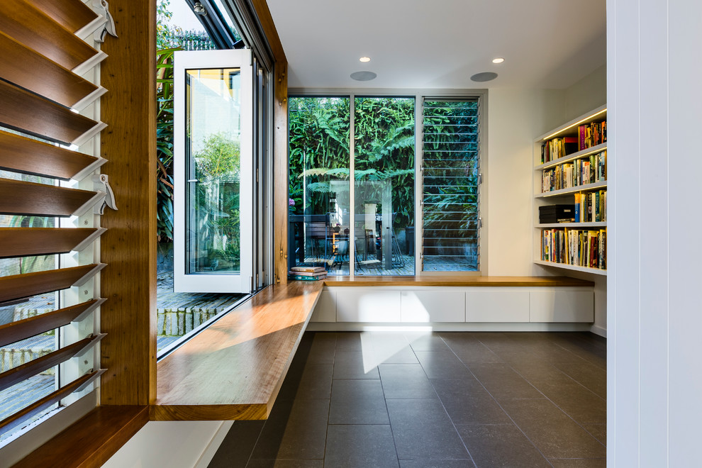 Idee per un soggiorno contemporaneo di medie dimensioni e aperto con libreria, pareti bianche, pavimento con piastrelle in ceramica e pavimento grigio
