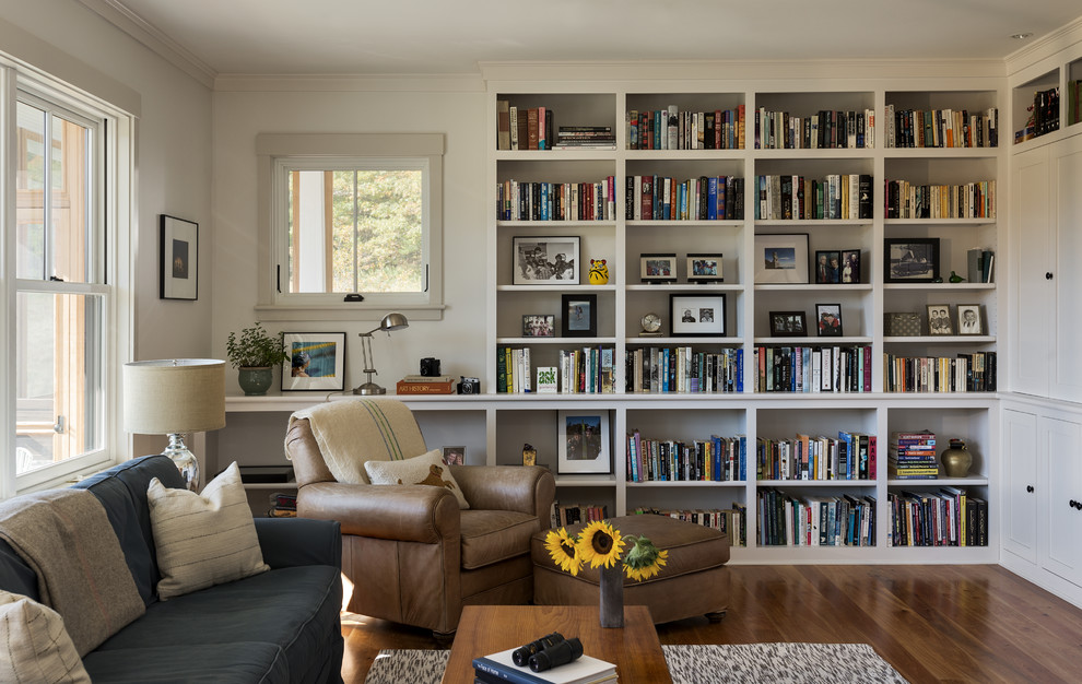 Inspiration for a mid-sized timeless open concept medium tone wood floor living room library remodel in Portland Maine with white walls, a standard fireplace and a stone fireplace