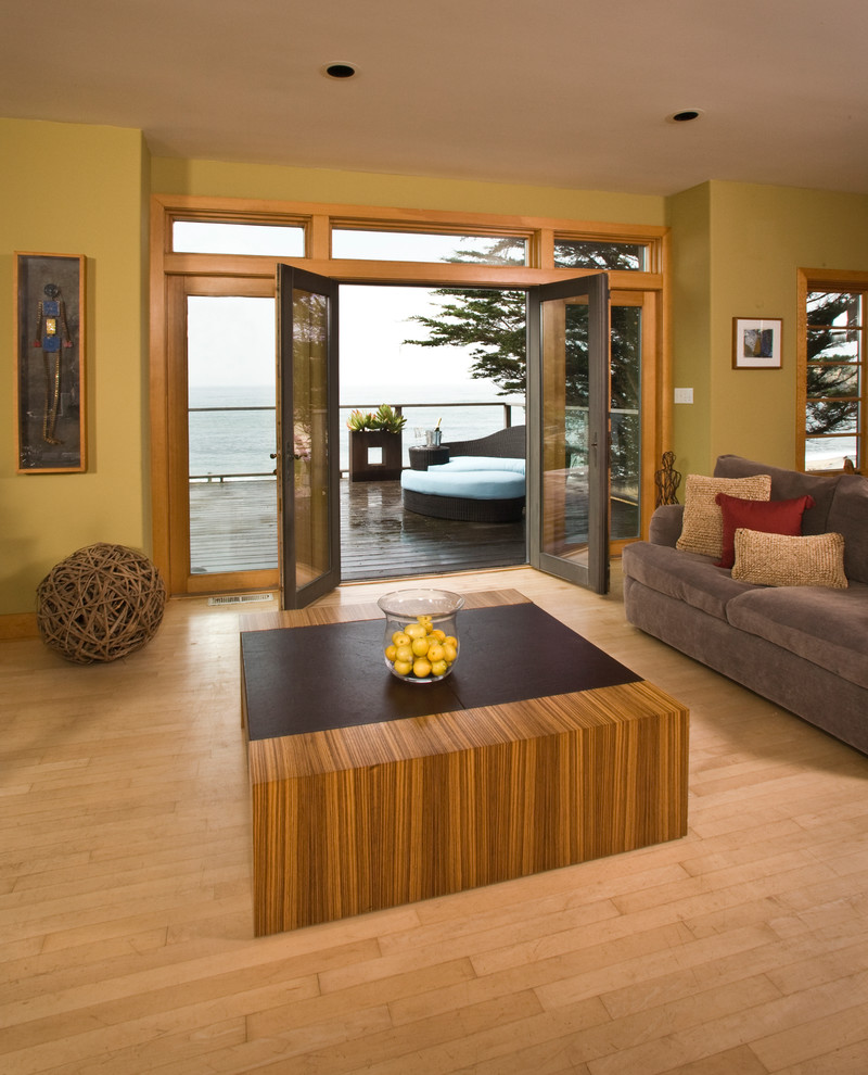 This is an example of a medium sized world-inspired living room in San Francisco with green walls, light hardwood flooring and no fireplace.