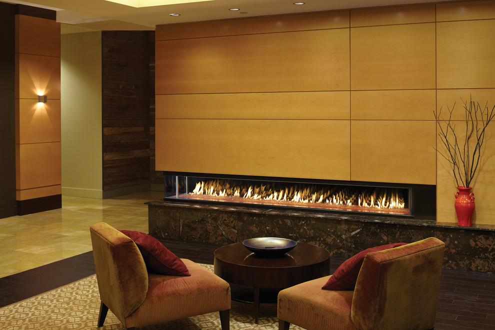 シアトルにある広いコンテンポラリースタイルのおしゃれなリビング (ベージュの壁、濃色無垢フローリング、両方向型暖炉、木材の暖炉まわり、茶色い床) の写真