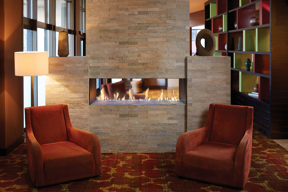 シアトルにある広いコンテンポラリースタイルのおしゃれなLDK (オレンジの壁、カーペット敷き、横長型暖炉、石材の暖炉まわり、マルチカラーの床) の写真
