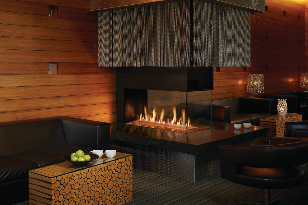 巨大なコンテンポラリースタイルのおしゃれなリビング (茶色い壁、カーペット敷き、横長型暖炉、石材の暖炉まわり、マルチカラーの床) の写真