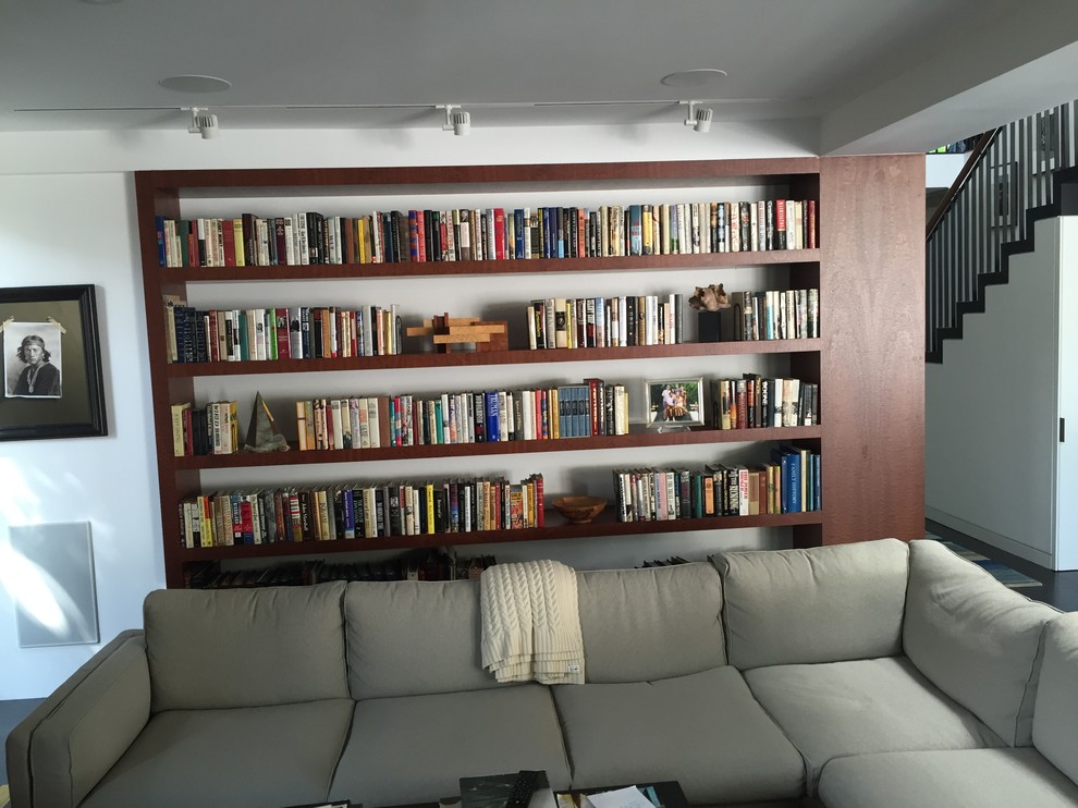 Foto de biblioteca en casa abierta contemporánea de tamaño medio con paredes blancas y suelo de cemento