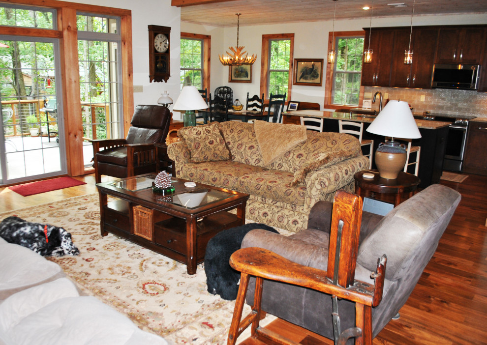 Esempio di un grande soggiorno stile rurale con pareti bianche, pavimento in legno massello medio e pavimento marrone