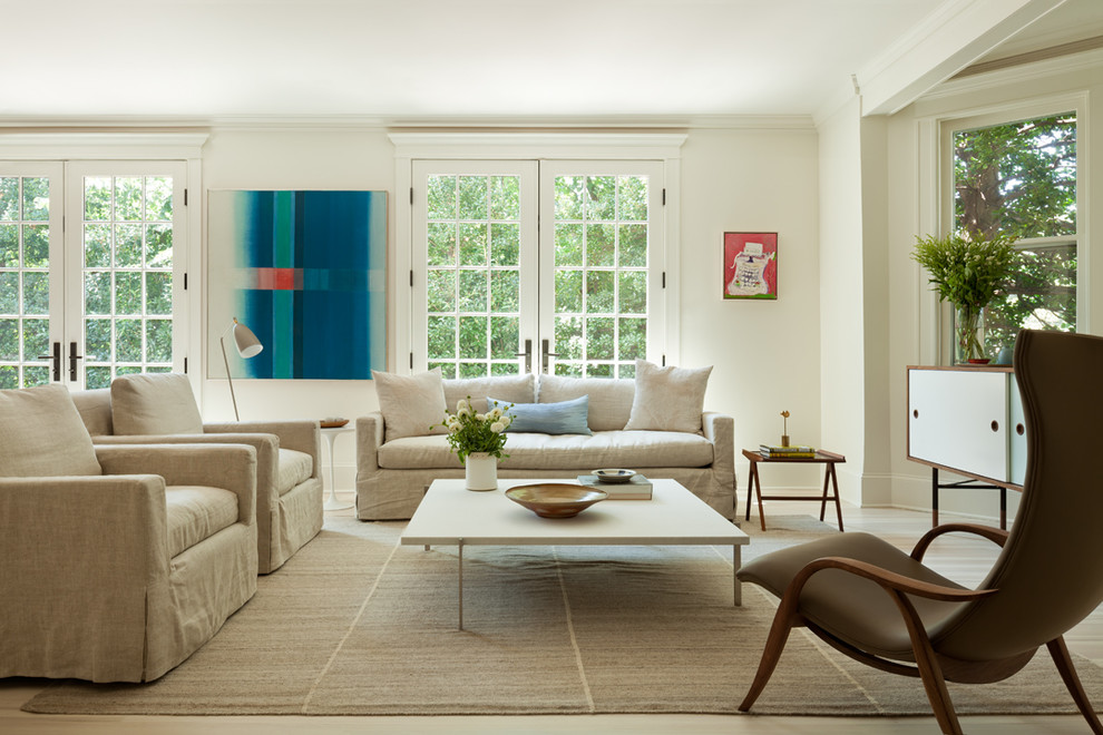 На фото: гостиная комната в стиле неоклассика (современная классика) с белыми стенами, светлым паркетным полом, бежевым полом и эркером с