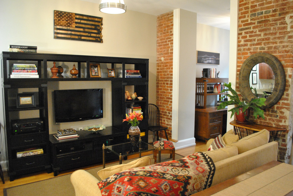 Exempel på ett litet klassiskt allrum med öppen planlösning, med grå väggar, ljust trägolv och en väggmonterad TV