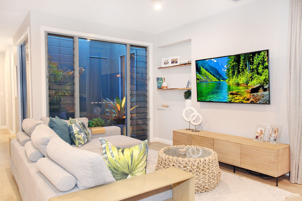 Cette image montre un petit salon design ouvert avec un mur blanc, parquet clair, un téléviseur fixé au mur et un sol jaune.