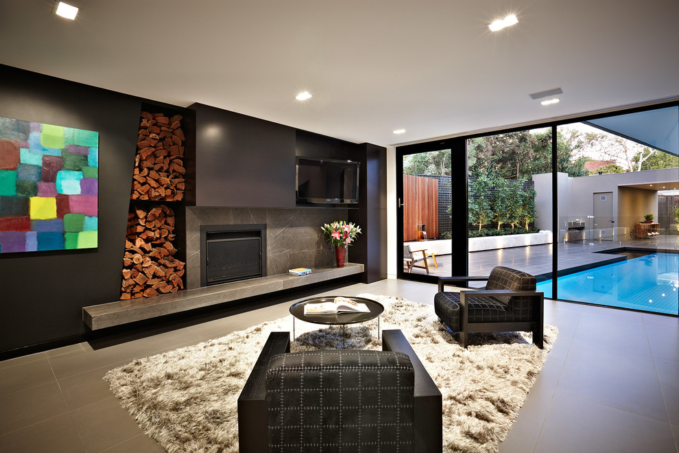 Inredning av ett modernt vardagsrum, med svarta väggar, en standard öppen spis och en väggmonterad TV