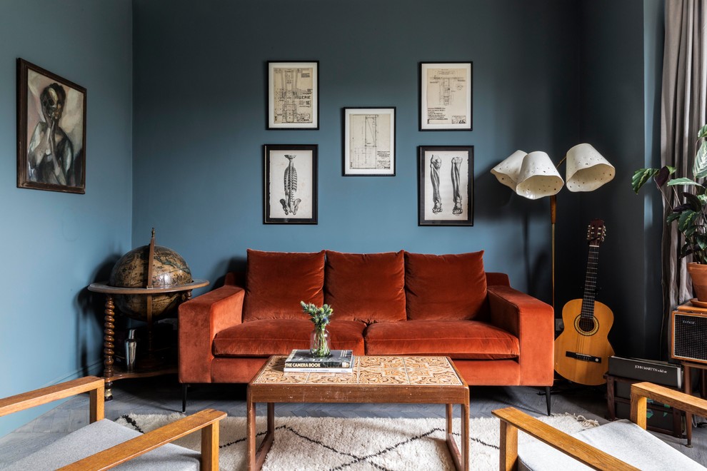 This is an example of a medium sized contemporary grey and teal enclosed living room in London with blue walls, light hardwood flooring, grey floors and feature lighting.