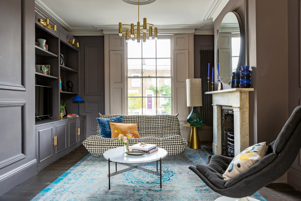 Example of a large eclectic formal and enclosed dark wood floor and brown floor living room design in London with gray walls, a standard fireplace, a stone fireplace and a media wall