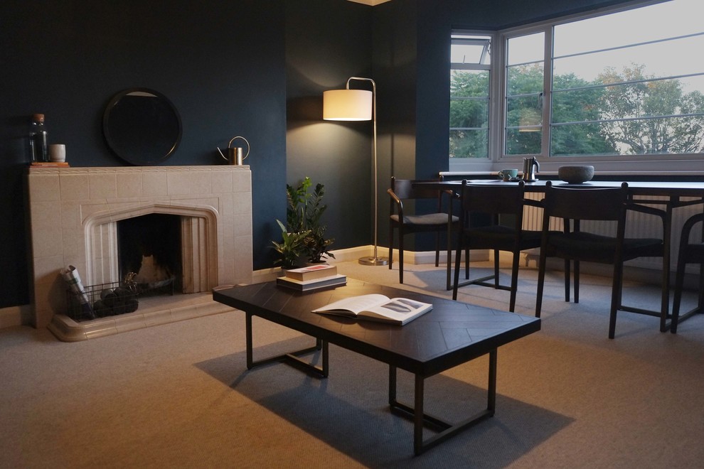 Foto på ett mellanstort funkis separat vardagsrum, med blå väggar, heltäckningsmatta, en standard öppen spis, en spiselkrans i trä och grått golv