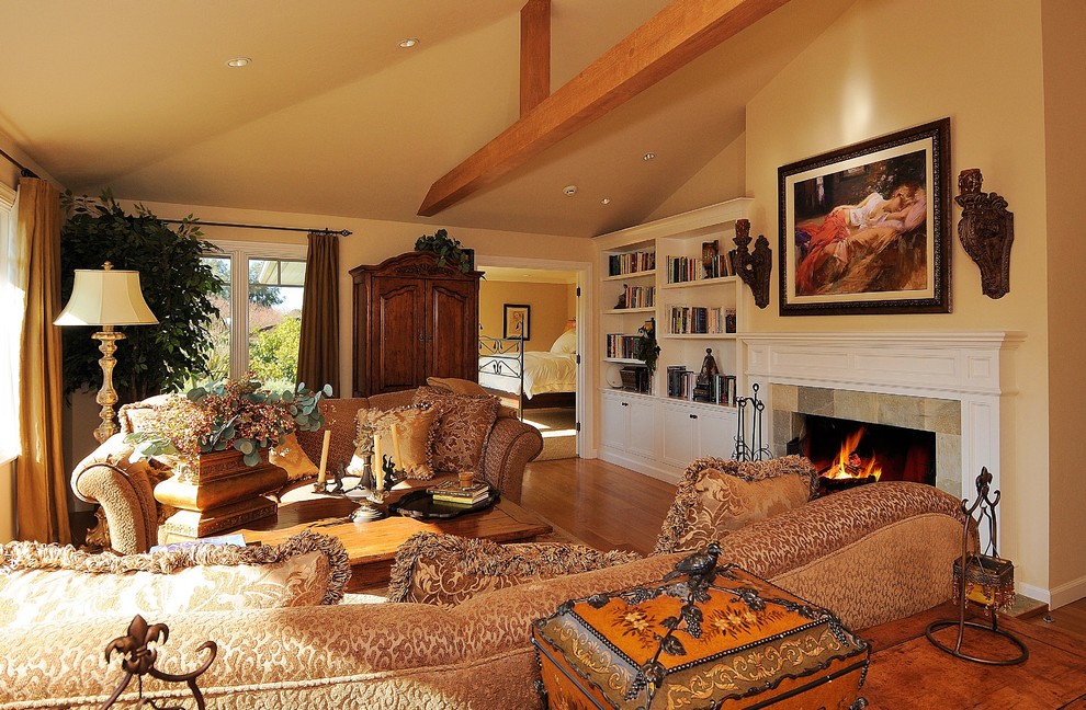 Exemple d'un salon chic de taille moyenne et fermé avec une cheminée standard, un manteau de cheminée en carrelage, une salle de réception, un mur beige, un sol en bois brun, aucun téléviseur et un sol beige.