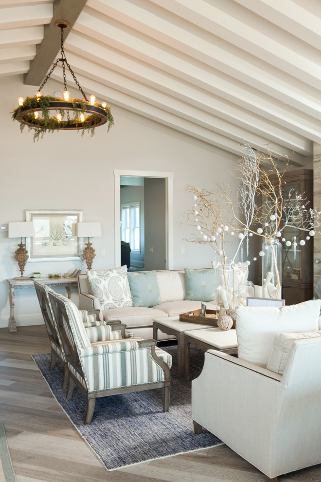 Foto de salón abierto costero grande con paredes blancas, suelo de madera clara, todas las chimeneas y televisor colgado en la pared