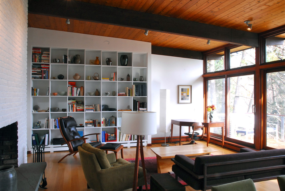 Example of a minimalist medium tone wood floor living room library design in Boston