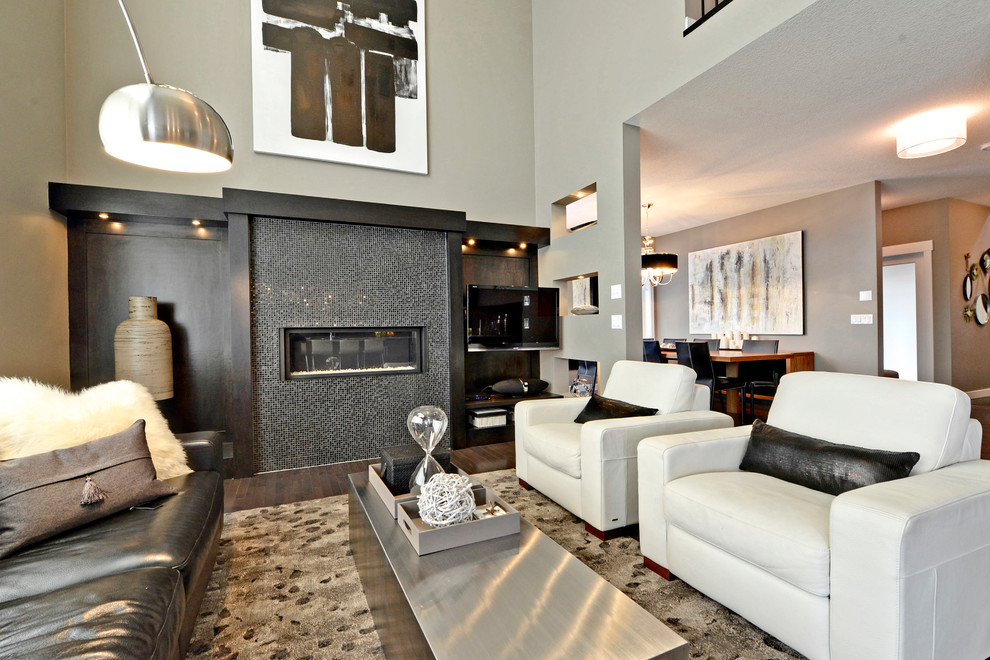 Großes, Repräsentatives, Offenes Modernes Wohnzimmer mit beiger Wandfarbe, dunklem Holzboden, Gaskamin, gefliester Kaminumrandung und TV-Wand in Calgary