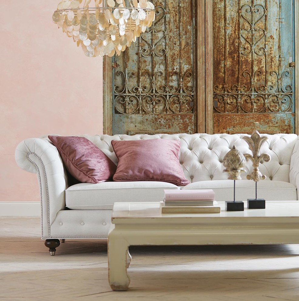 Example of an eclectic painted wood floor and beige floor living room design with pink walls
