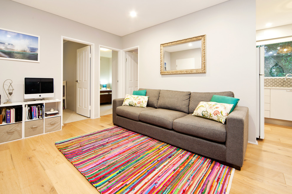 Exemple d'un petit salon moderne ouvert avec un mur gris, parquet clair et un téléviseur indépendant.