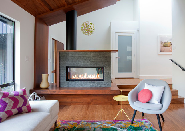 バンクーバーにある広いコンテンポラリースタイルのおしゃれなLDK (白い壁、竹フローリング、両方向型暖炉、石材の暖炉まわり) の写真