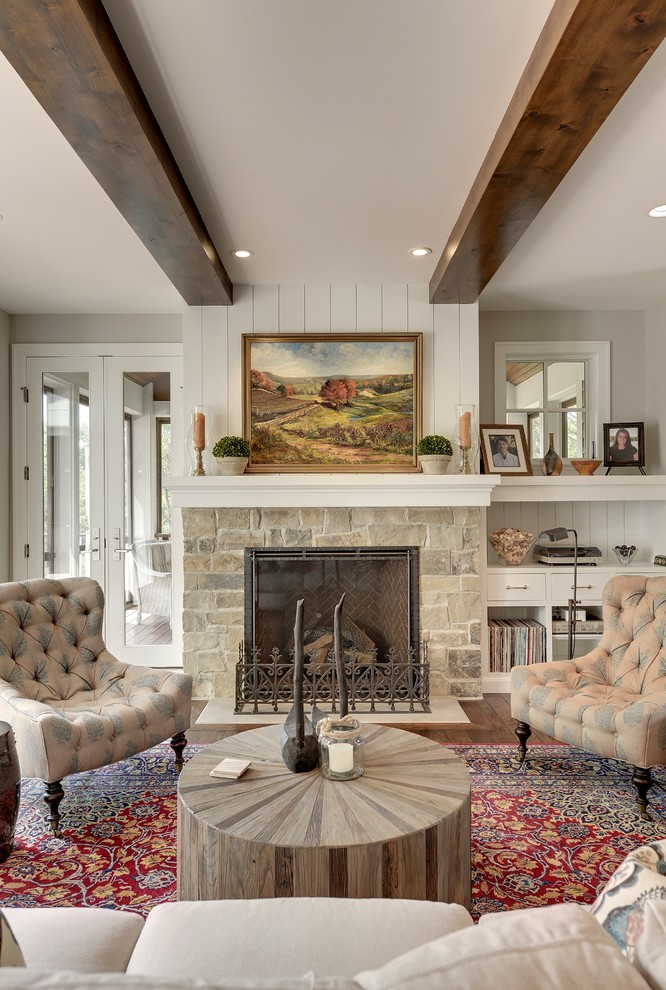 Traditional living room in Minneapolis with grey walls, dark hardwood flooring, a standard fireplace and a stone fireplace surround.