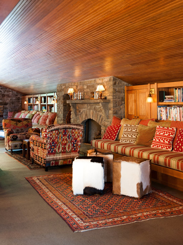 Immagine di un soggiorno rustico di medie dimensioni e stile loft con libreria, camino classico e cornice del camino in pietra