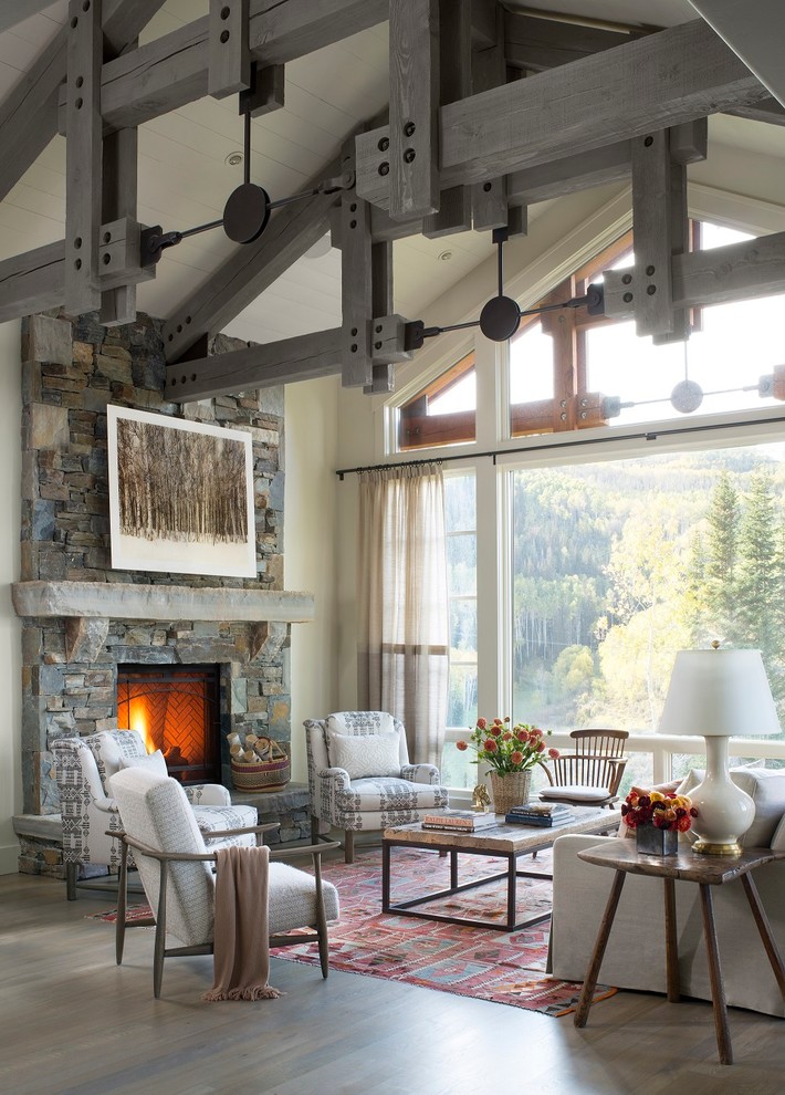Example of a mountain style medium tone wood floor living room design in Seattle with white walls, a standard fireplace and a stone fireplace