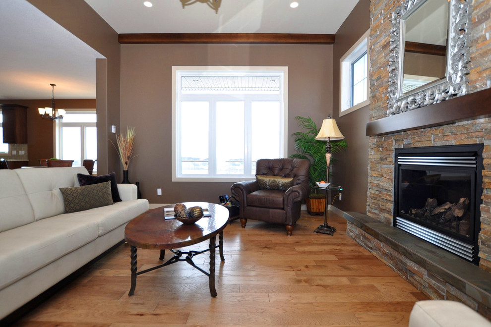 На фото: парадная гостиная комната в стиле рустика с коричневыми стенами, светлым паркетным полом, стандартным камином и фасадом камина из камня