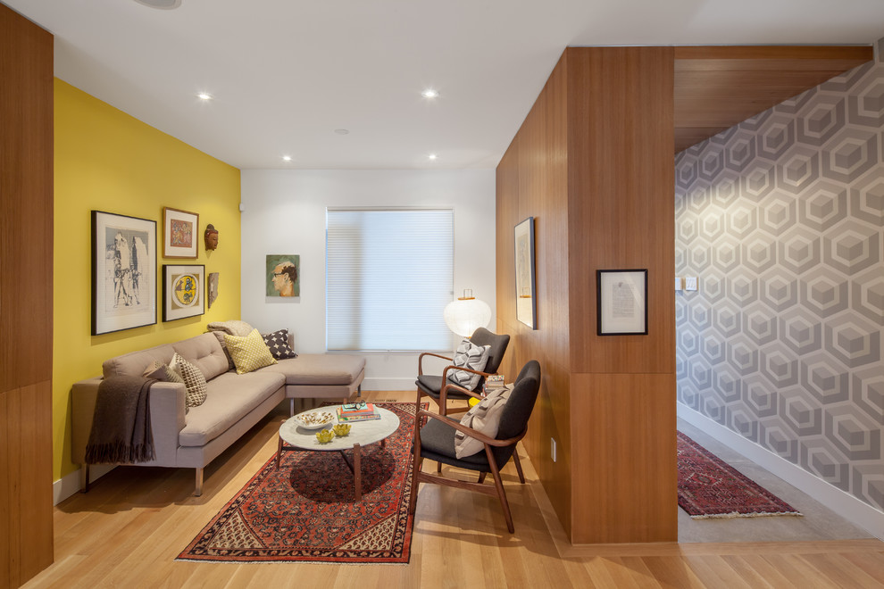 Bild på ett funkis vardagsrum, med ett finrum, gula väggar och ljust trägolv