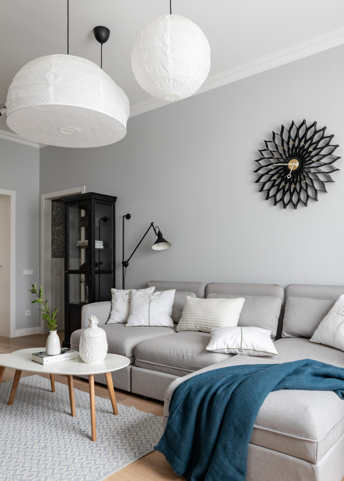 Пример оригинального дизайна: открытая гостиная комната среднего размера в скандинавском стиле с серыми стенами, светлым паркетным полом и бежевым полом