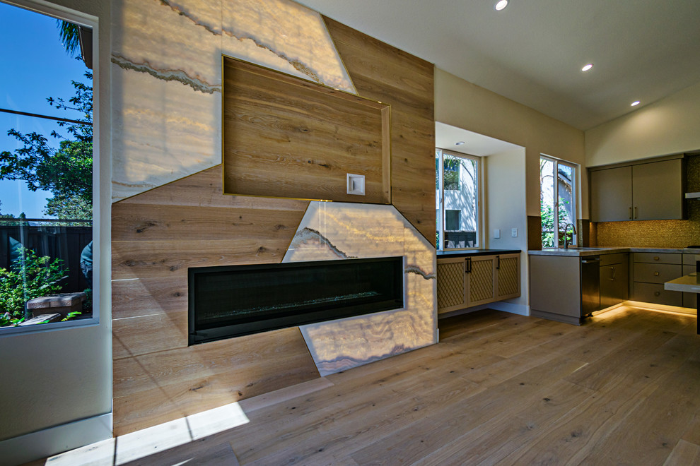 На фото: открытая гостиная комната среднего размера в современном стиле с светлым паркетным полом, коричневым полом, горизонтальным камином, фасадом камина из дерева и телевизором на стене с