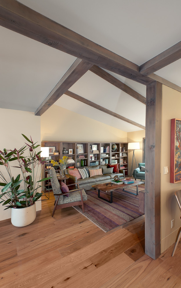 Cette photo montre un salon chic de taille moyenne et ouvert avec un mur beige, un sol en bois brun, aucune cheminée et un sol marron.