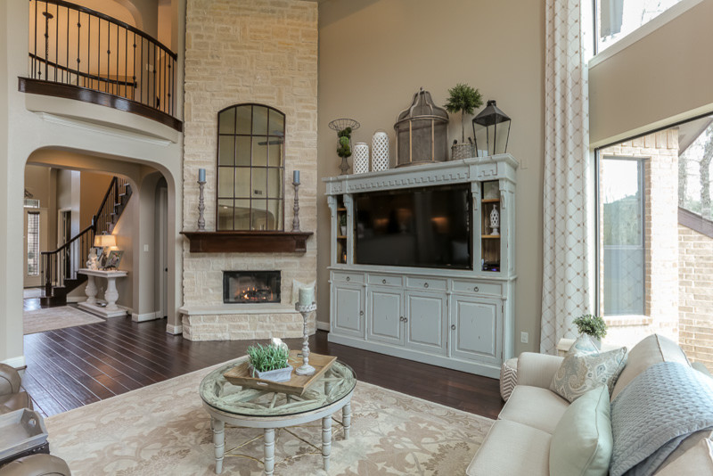 Example of a large transitional open concept dark wood floor living room design in Houston with beige walls, a corner fireplace, a stone fireplace and a tv stand
