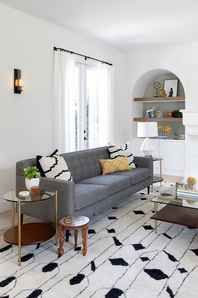 Mittelgroßes, Offenes Stilmix Wohnzimmer mit weißer Wandfarbe, hellem Holzboden, Kamin, verputzter Kaminumrandung und TV-Wand in San Diego
