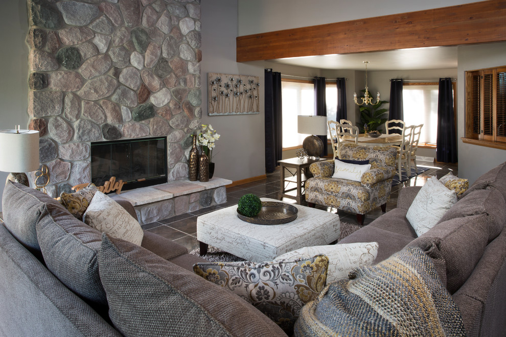 Inspiration for a large traditional formal open plan living room in Milwaukee with grey walls, porcelain flooring, a standard fireplace, a stone fireplace surround, no tv, grey floors and feature lighting.