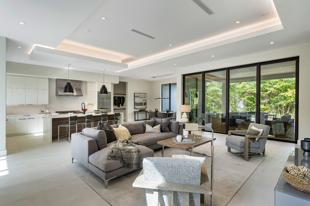 Contemporary open plan living room in Miami with beige walls and grey floors.