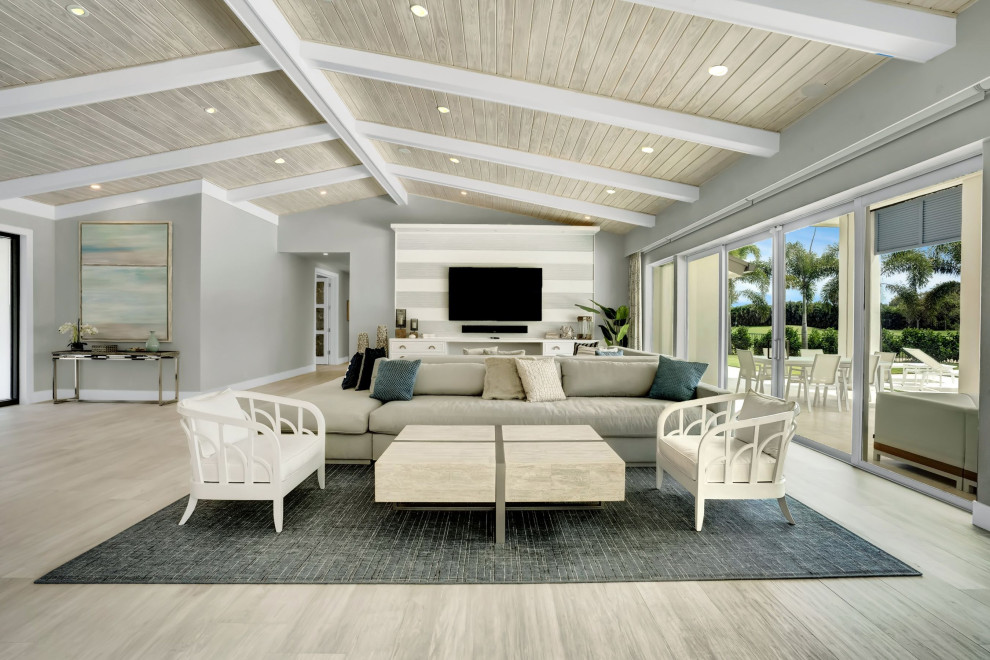 Geräumiges, Offenes Maritimes Wohnzimmer mit Porzellan-Bodenfliesen, grauem Boden, Holzdielendecke und Tapetenwänden in Miami