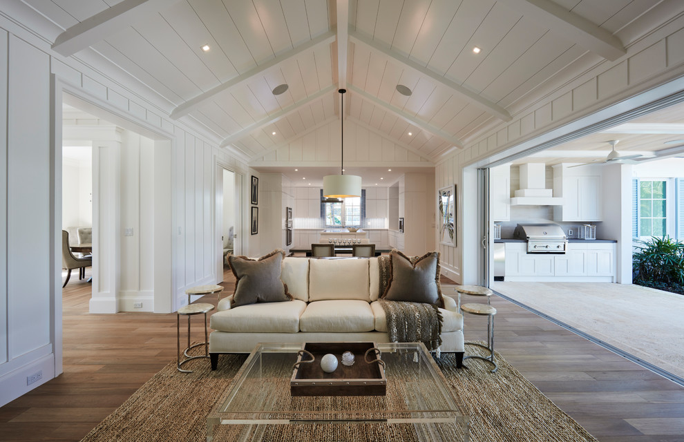 Idee per un grande soggiorno stile marinaro aperto con pareti bianche, pavimento in legno massello medio, nessun camino e TV a parete
