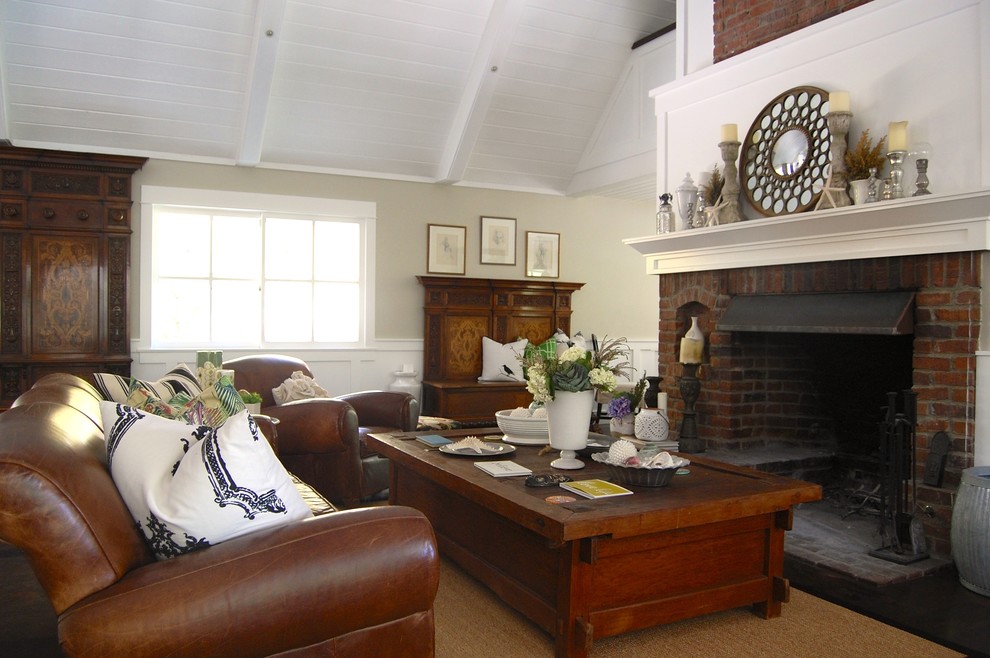 Cette photo montre un salon chic avec un mur beige, une cheminée standard et un manteau de cheminée en brique.
