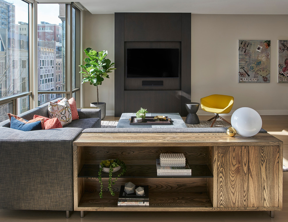 Diseño de salón abierto contemporáneo sin chimenea con paredes beige, suelo de madera en tonos medios, televisor colgado en la pared y suelo marrón