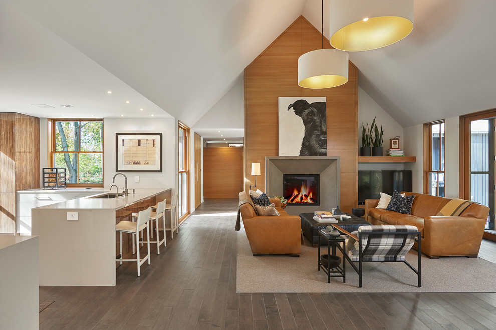 Aménagement d'un grand salon contemporain ouvert avec un mur blanc, une cheminée standard, un manteau de cheminée en béton, un sol gris, un sol en bois brun, un téléviseur indépendant et un plafond cathédrale.