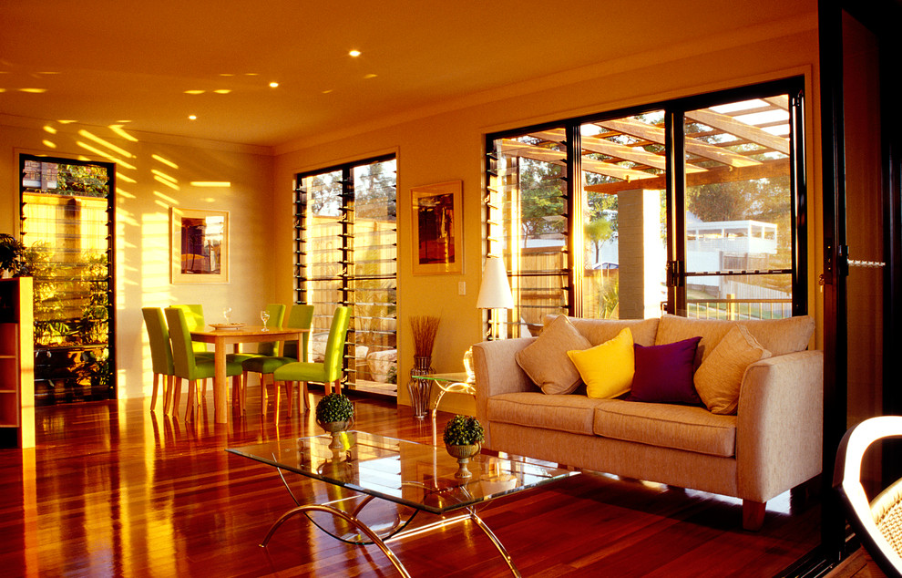 Стильный дизайн: открытая гостиная комната среднего размера в современном стиле с желтыми стенами и паркетным полом среднего тона - последний тренд