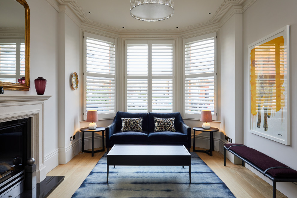 Imagen de salón cerrado minimalista de tamaño medio con paredes blancas y suelo de madera clara
