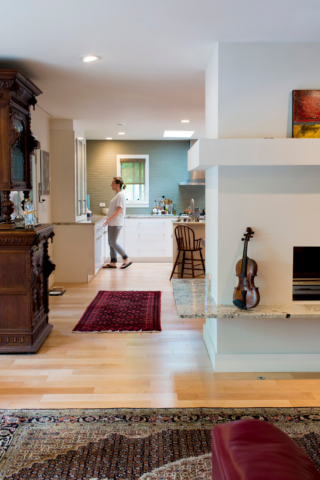 Diseño de salón abierto minimalista de tamaño medio con suelo de madera clara y chimenea de doble cara