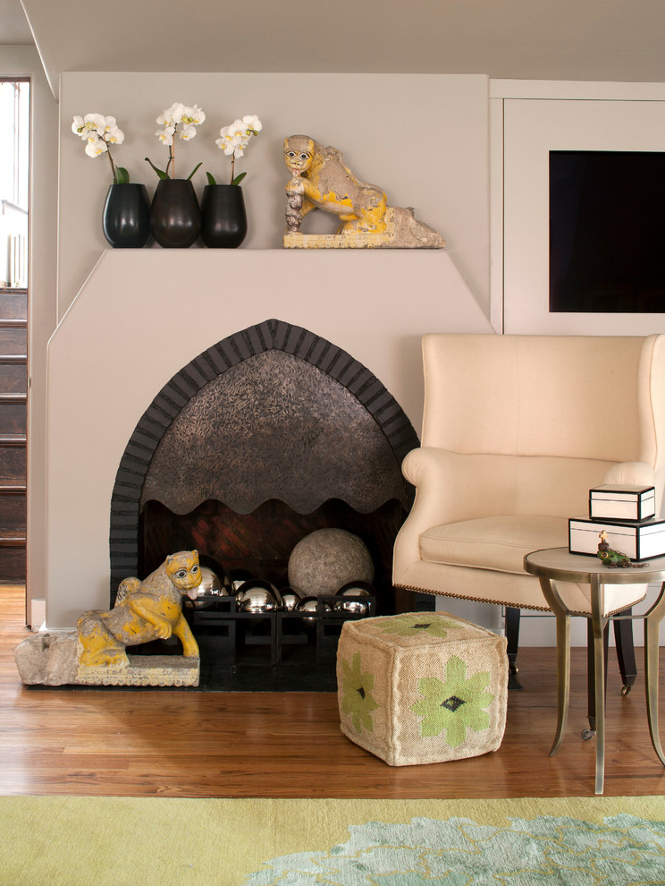 デンバーにあるエクレクティックスタイルのおしゃれなリビング (ベージュの壁、無垢フローリング、標準型暖炉、壁掛け型テレビ) の写真